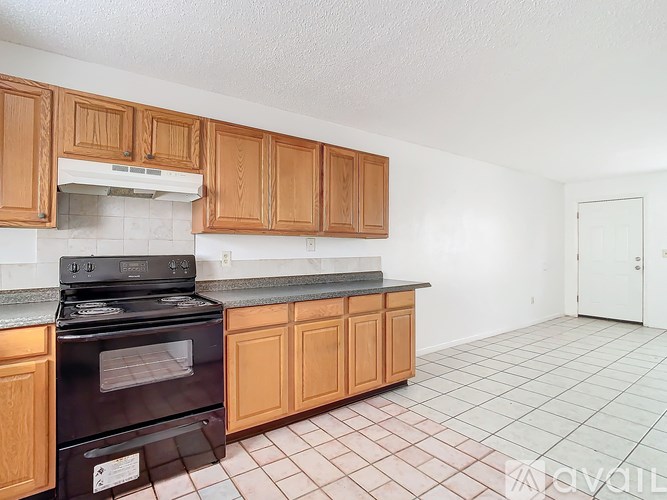 A kitchen with wooden cabinets and a black stove top oven.