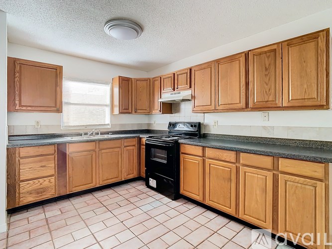 A kitchen with wooden cabinets and a black stove top oven.