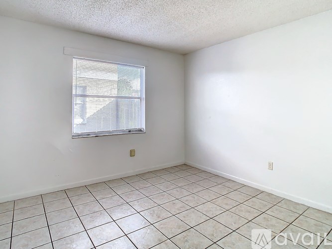 A room with a window and tiled floor.
