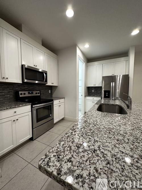 A kitchen with granite countertops and stainless steel appliances.