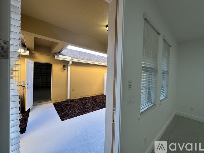 A hallway with a carpeted floor and a door on the right side.
