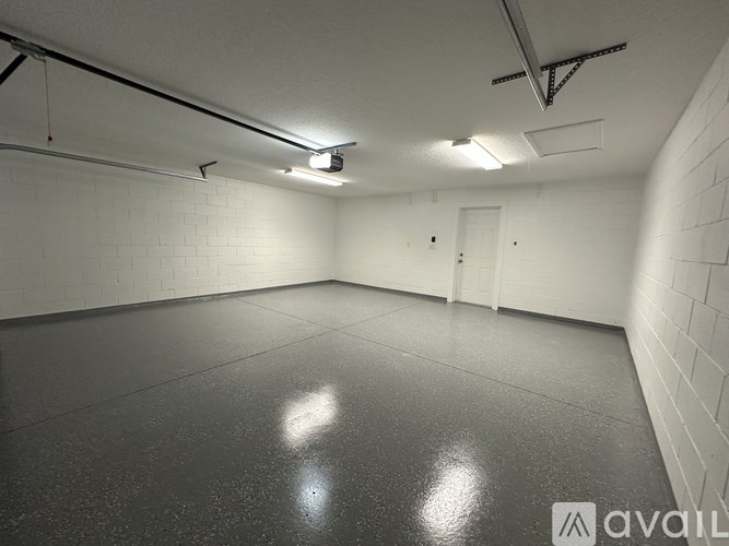 A spacious, empty room with a concrete floor and white walls.