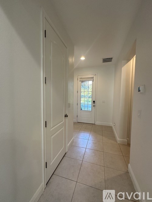 A hallway with white doors and a tiled floor.