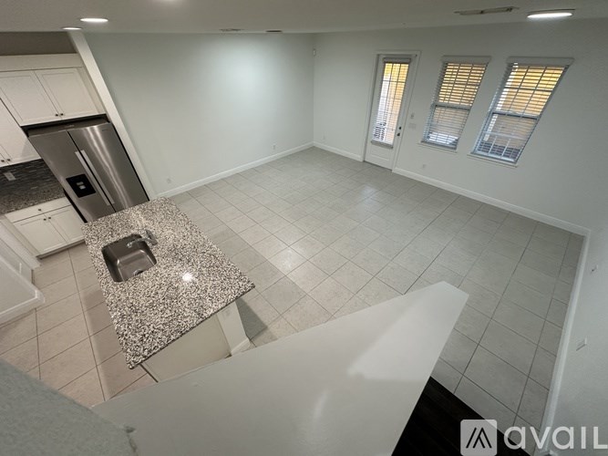 A kitchen with a granite countertop and stainless steel appliances.