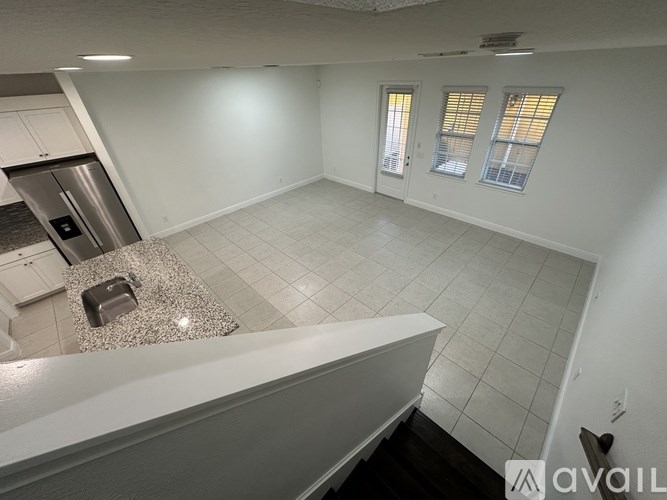 A kitchen with a stainless steel refrigerator and a granite countertop.