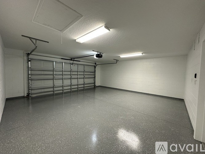 A spacious garage with a grey floor and white walls.