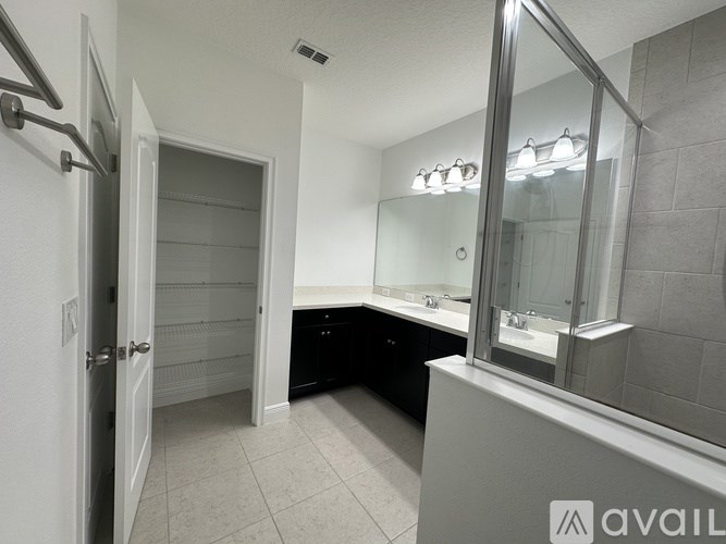 A bathroom with a sink, mirror, and a white door.