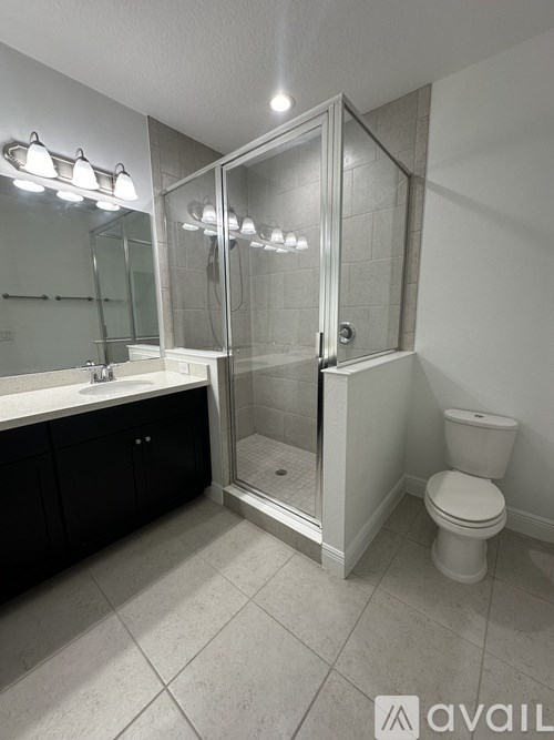 A bathroom with a toilet, sink, and shower.