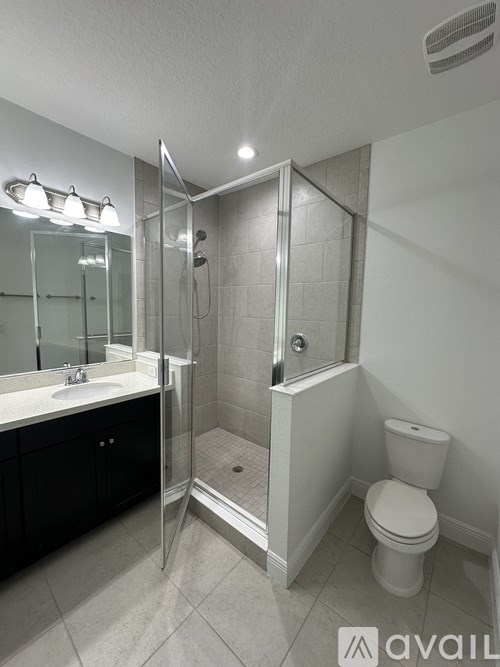 A bathroom with a toilet, sink, and shower.