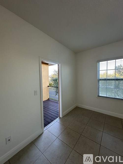 A room with a tiled floor and a window with blinds.