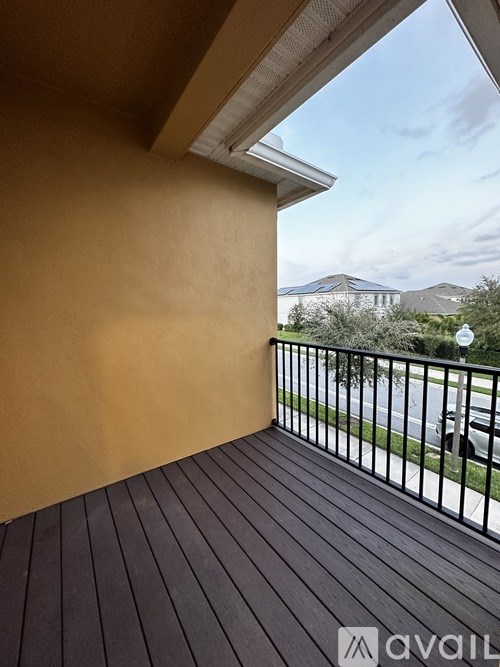A balcony with a black railing and wooden planks.