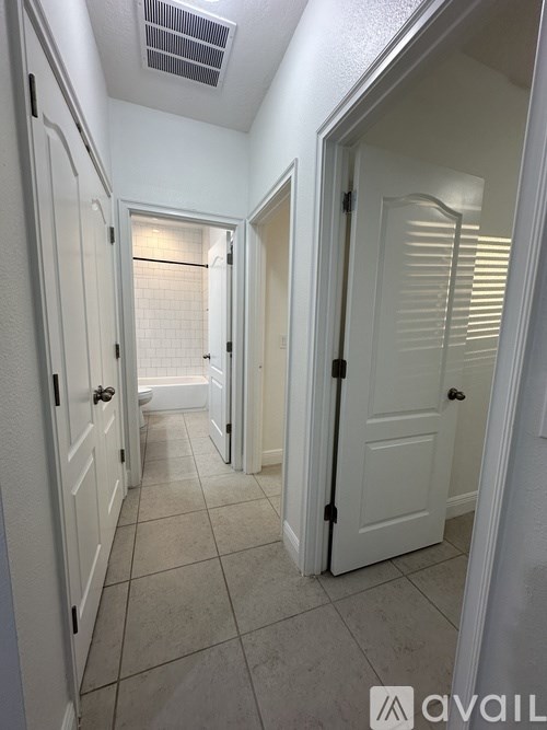 A hallway with white doors and tiled floors.
