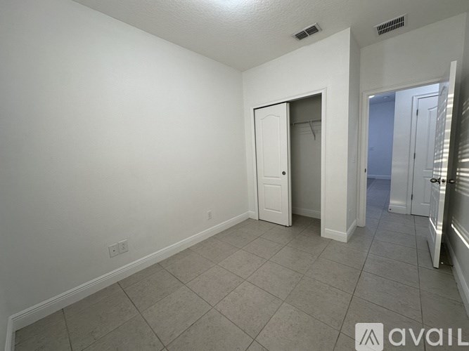 A room with a white door and a tiled floor.