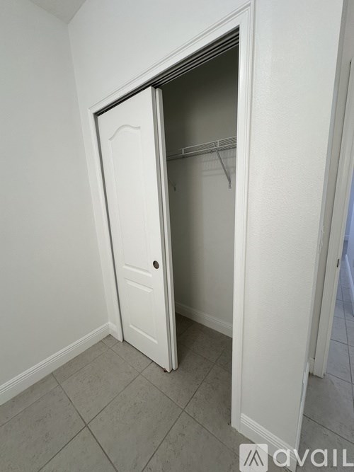 A white door is open to a small closet.