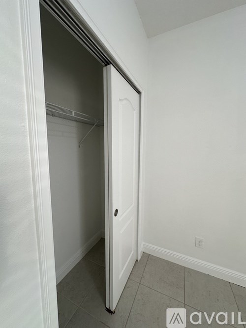 A small white closet with a door open.