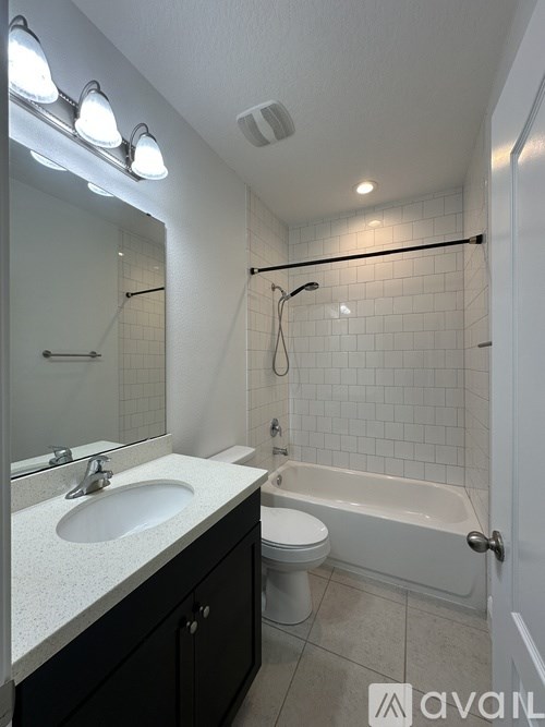 A bathroom with a sink, toilet, and bathtub.