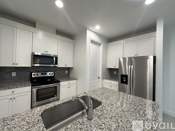 A kitchen with granite countertops and stainless steel appliances.