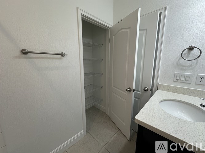 A white bathroom with a sink, toilet, and a shower stall.