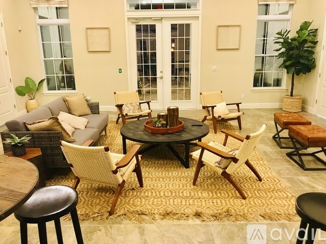 A living room with a round table surrounded by chairs.