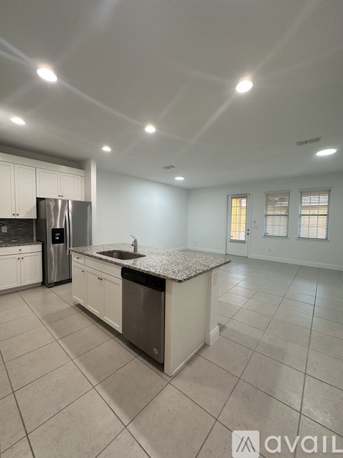 A kitchen with white cabinets and a granite countertop.