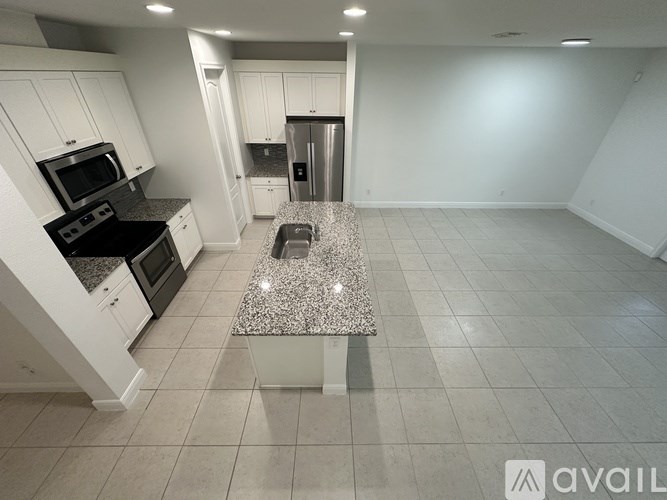 A kitchen with granite countertops and white cabinets.