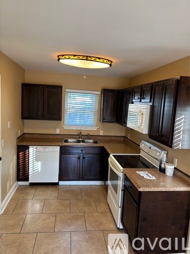 A kitchen with brown cabinets and a white fridge.