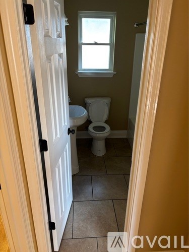 A bathroom with a toilet and a window.