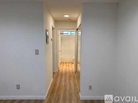 A long hallway with doors on both sides and a light on the wall.