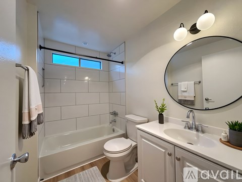 A bathroom with a toilet, sink, and tub.