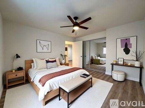 A bedroom with a bed, nightstand, and a ceiling fan.