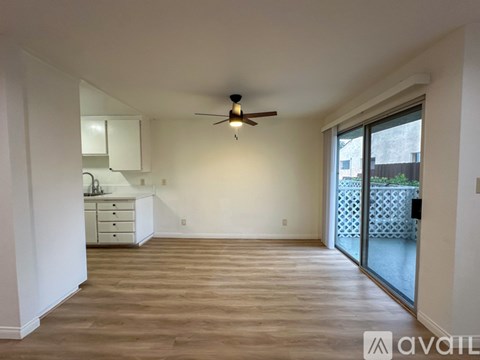 A spacious room with a ceiling fan and sliding glass doors.