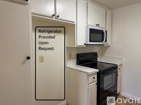 A sign on a door in a kitchen that says Refrigerator Provided Upon Request.