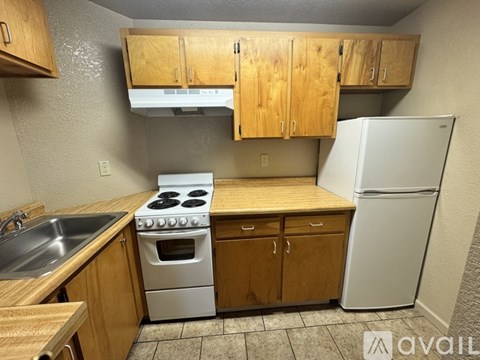 A kitchen with wooden cabinets and a white refrigerator.