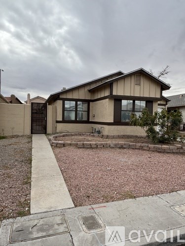 A house with a brown roof and a gravel driveway.
