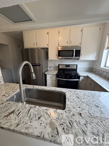 A kitchen with a marble countertop and stainless steel appliances.