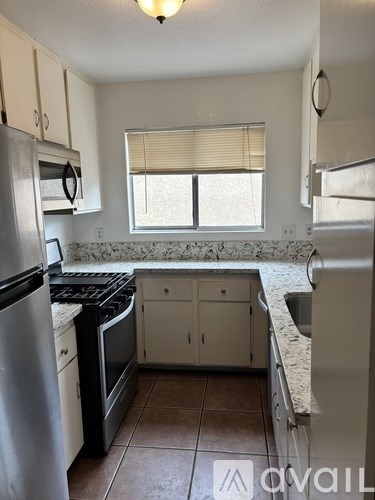 A kitchen with a stove top oven and a refrigerator.