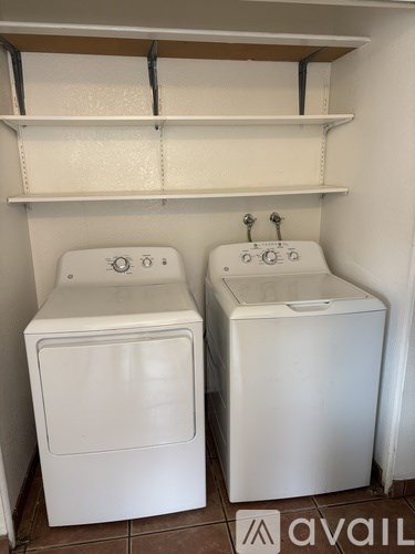 Two white washing machines in a small room.