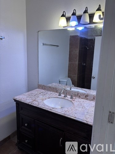 A bathroom with a sink and a mirror.