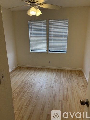 A room with wooden flooring and a ceiling fan.