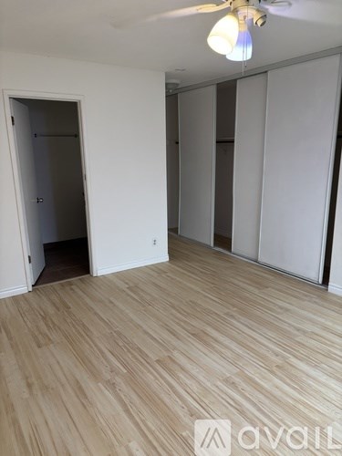 A room with wooden flooring and a ceiling fan.