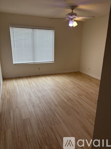 A room with wooden flooring and a ceiling fan.