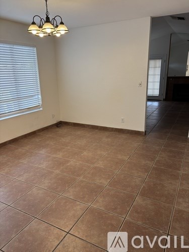 A room with brown tiles and a chandelier.
