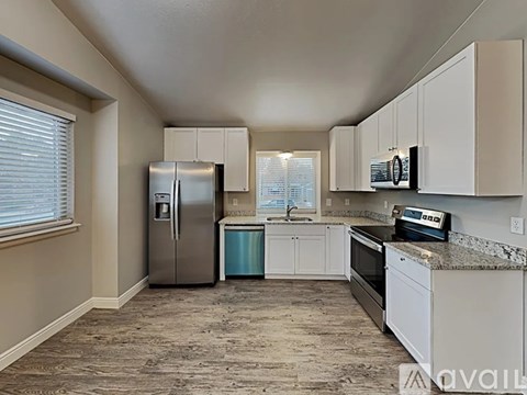 A kitchen with a refrigerator, oven, and microwave.