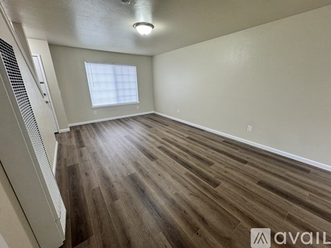 A room with wooden flooring and a window.