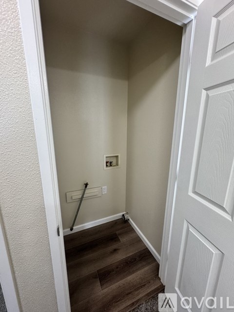 A hallway with a wooden floor and white walls.