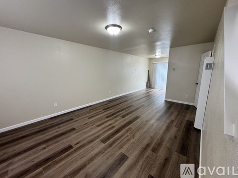 A room with wooden flooring and white walls.