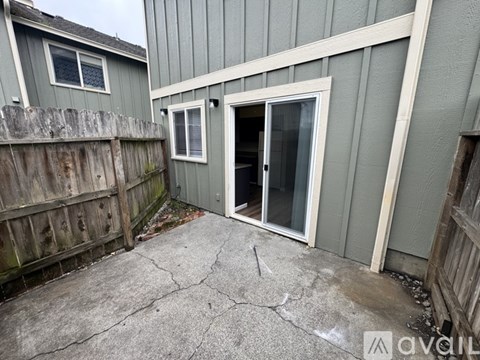 A grey house with a wooden fence and a grey door.