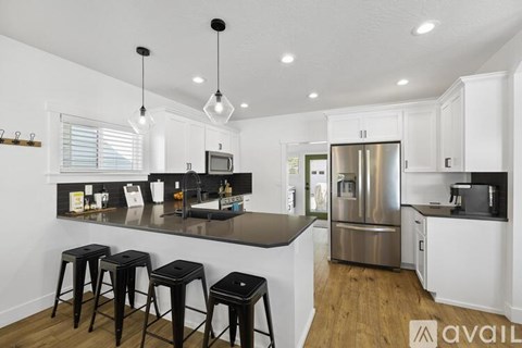 A kitchen with a bar area and a refrigerator.