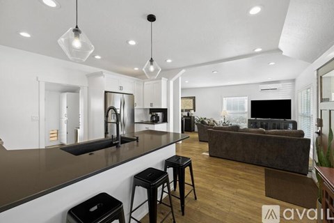 A modern kitchen with a bar area and a couch.