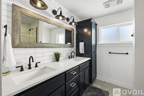A bathroom with a white sink and black cabinets.